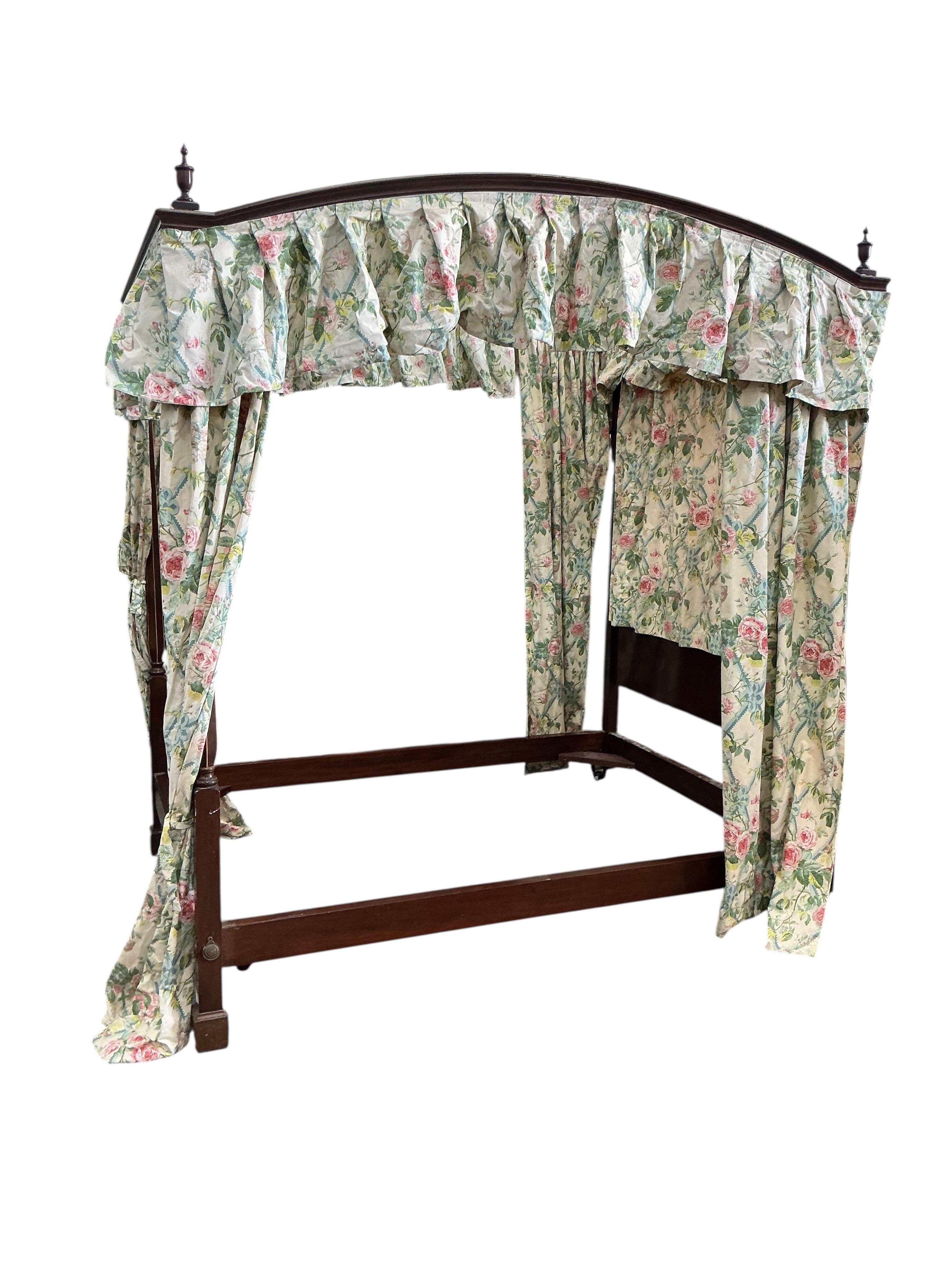 A George III style mahogany four poster bed, with floral drapes, width 150cm, length 208cm, height 220cm